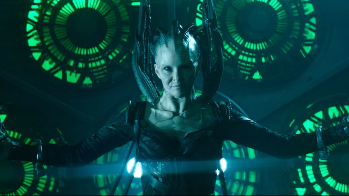 The Borg Queen with arms outstretched, green Borg technology glowing behind her